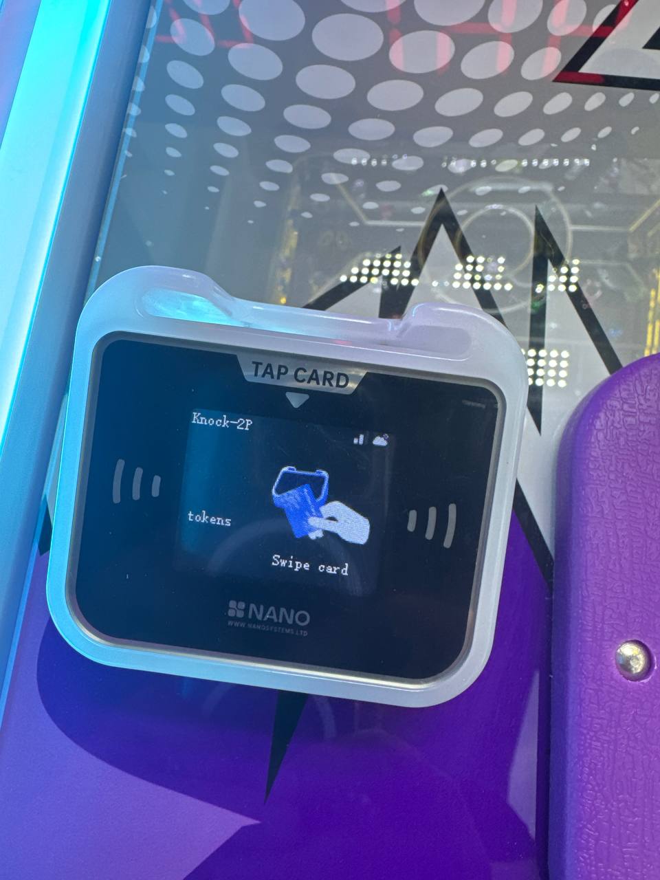 Thiết bị ThinkBox Arcade Cashless gắn trên máy arcade — chạm thẻ để chơi